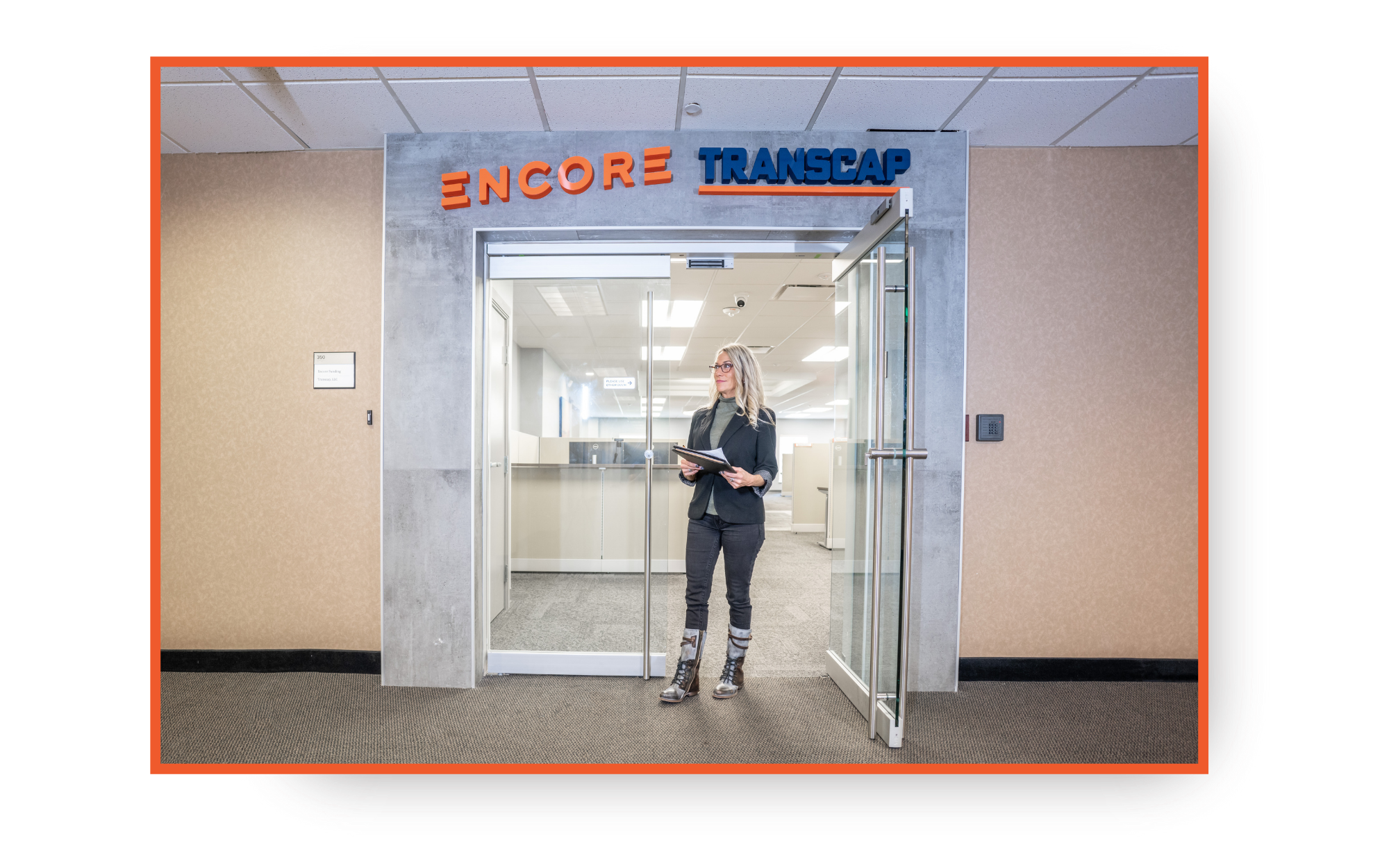 A woman standing outside of glass doors leading to an office